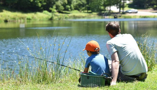 Father and Son Fishing. Dad Shows His Son How To Hold the Spinning